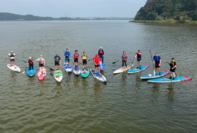 SUP Ausbildung: Gruppenbild von schräg oben von allen Teilnehmenden auf dem Wasser<br />
